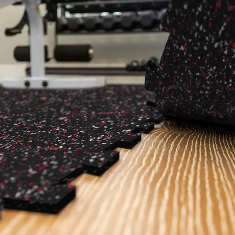 A black, red, and gray colored Ecore Athletic interlocking rubber gym flooring tile for homes