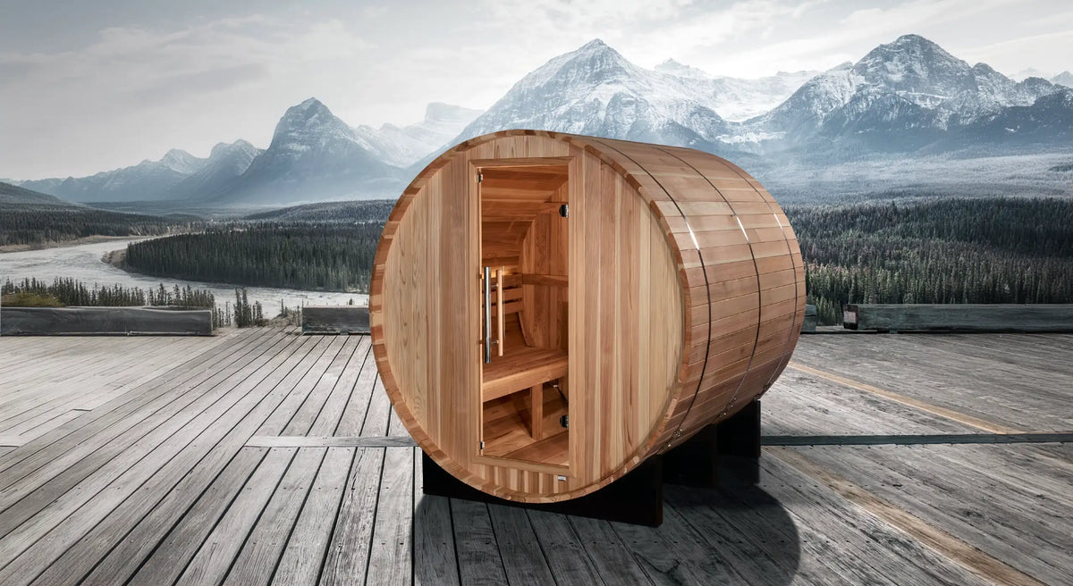 Golden Designs Arosa model barrel shaped sauna with a 4 person capacity which is built for outside use on a deck overlooking snow capped mountains