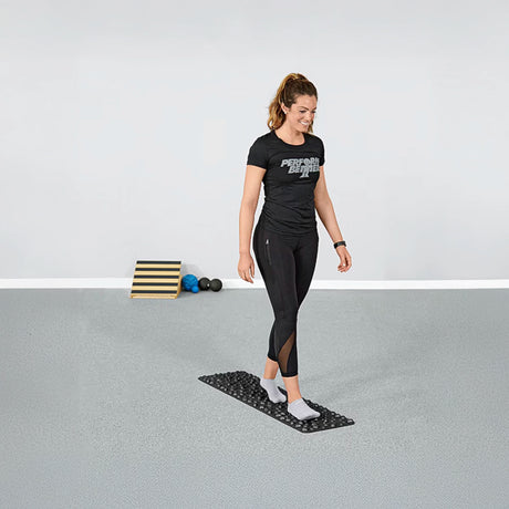 Woman walking on black rubber rock mat